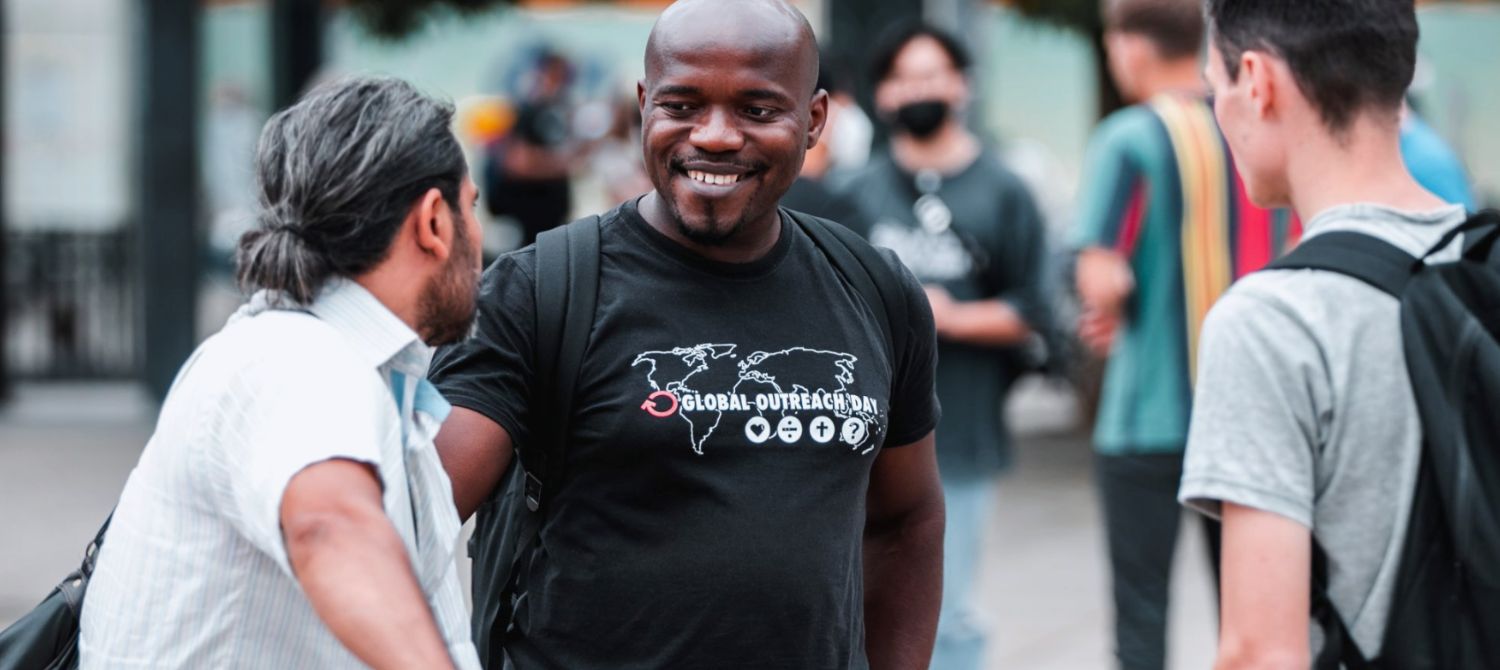 Man talking to two other men in the street